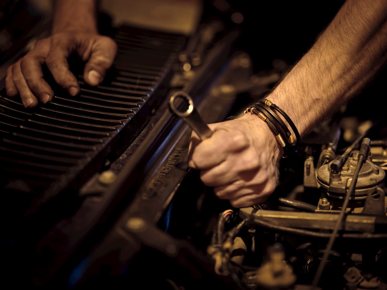Technician's hands turning a wrench on an open transmission during teardown