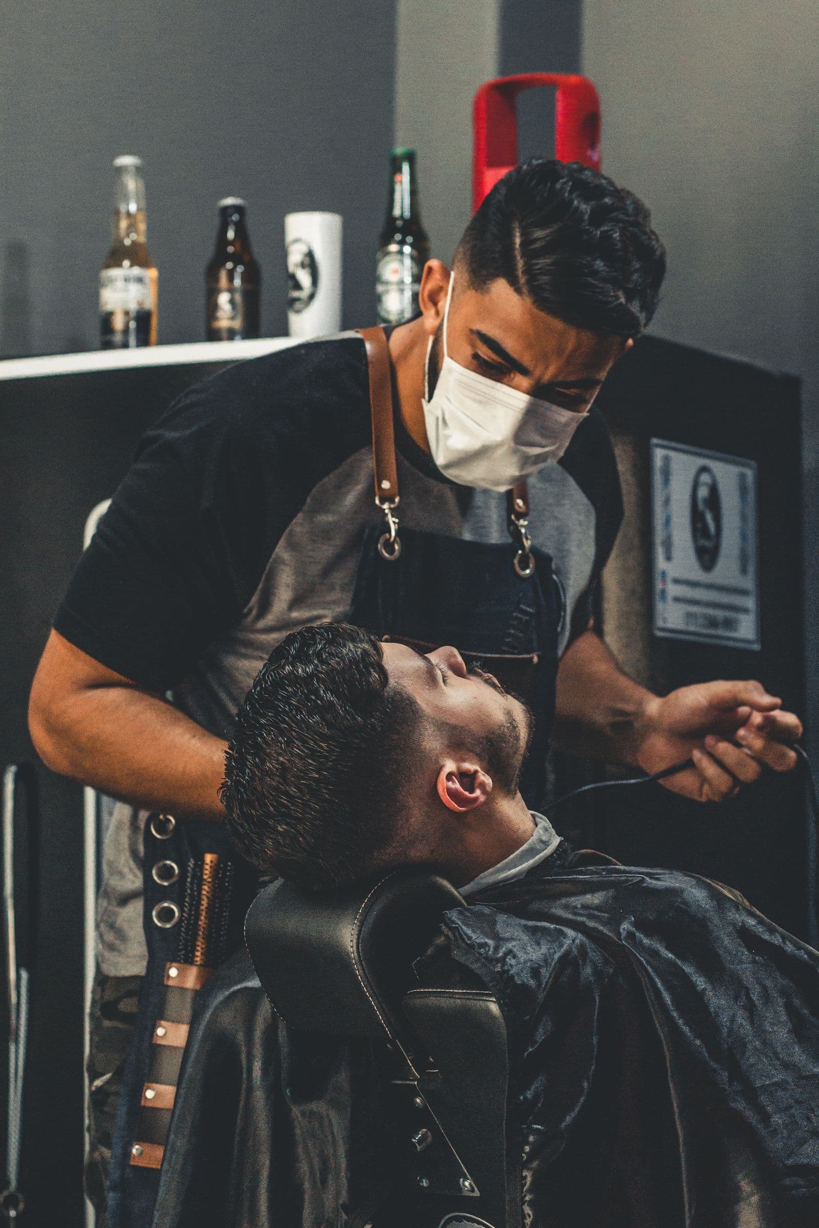 A dim, wood-panelled barber room lit by a single warm lamp over a leather chair