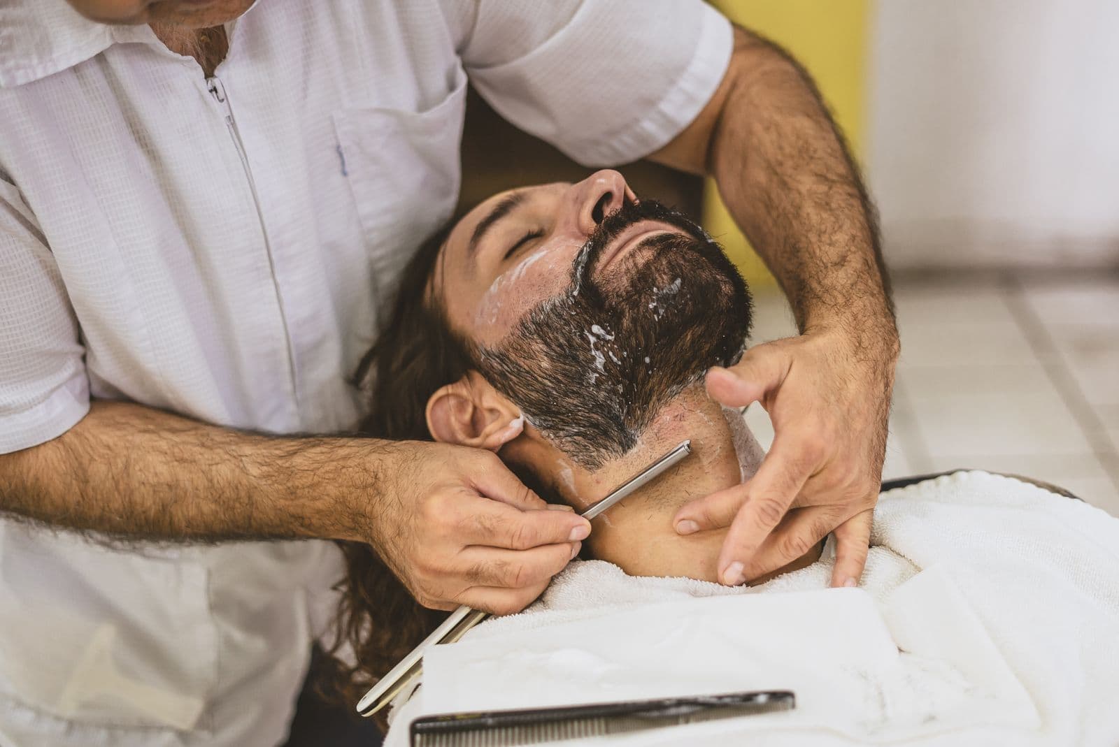 Warm lather being worked onto the jaw with a badger brush