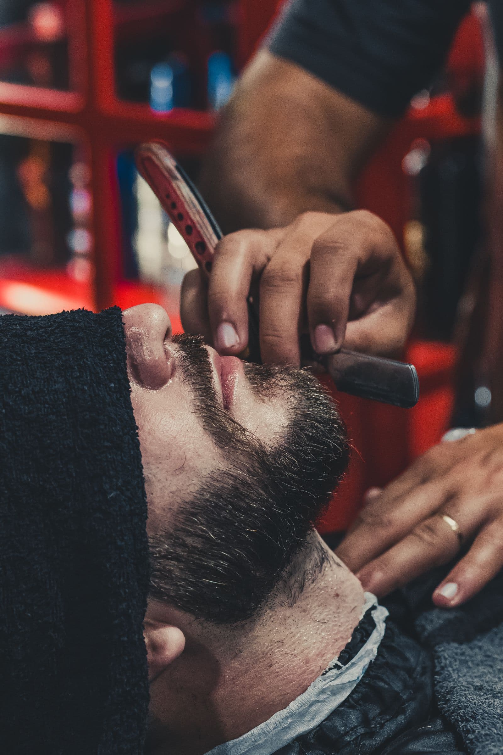 A straight-razor hot-towel shave in progress under warm light at Kingsway Turkish Barber