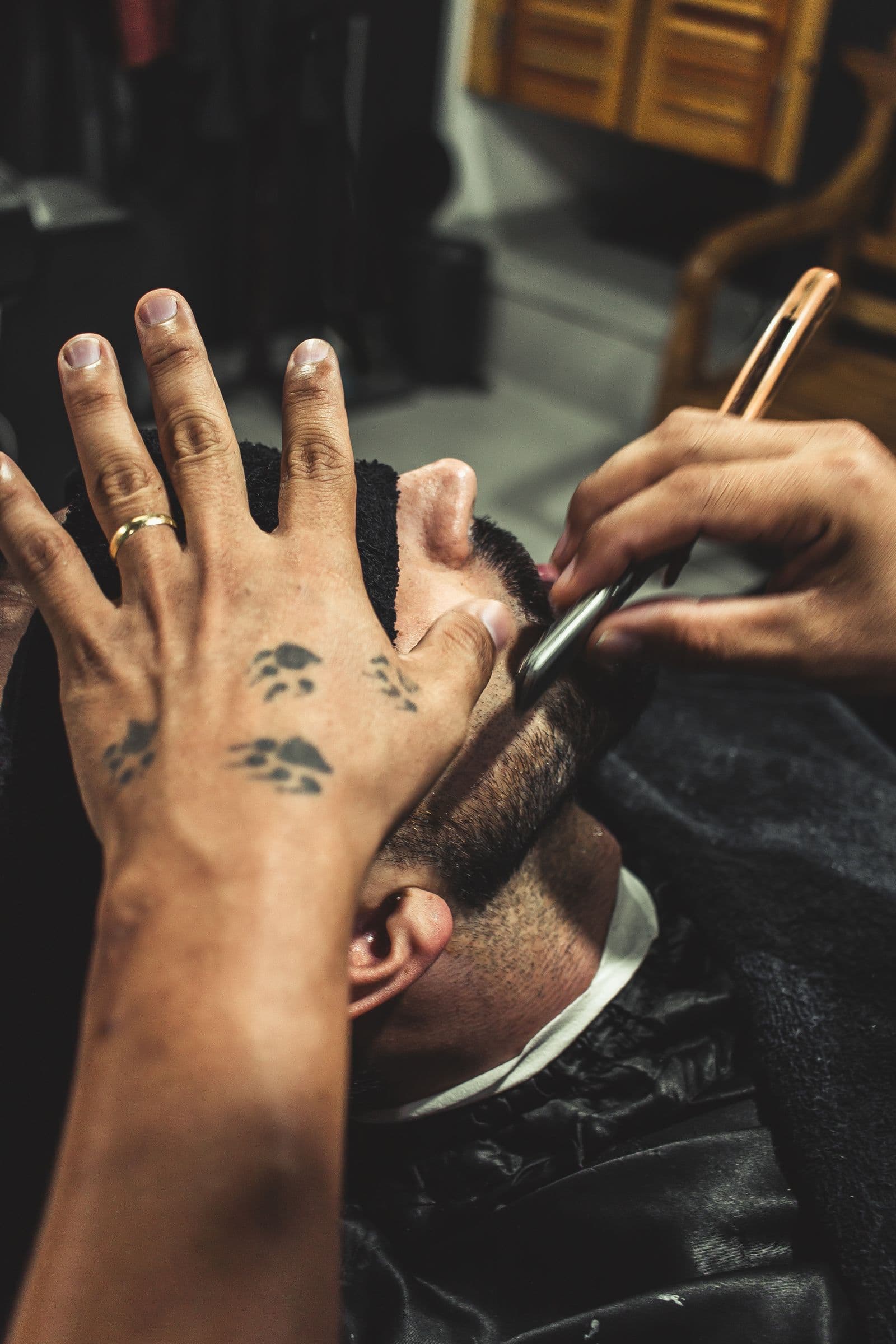 A straight razor drawn carefully through lather along the cheek