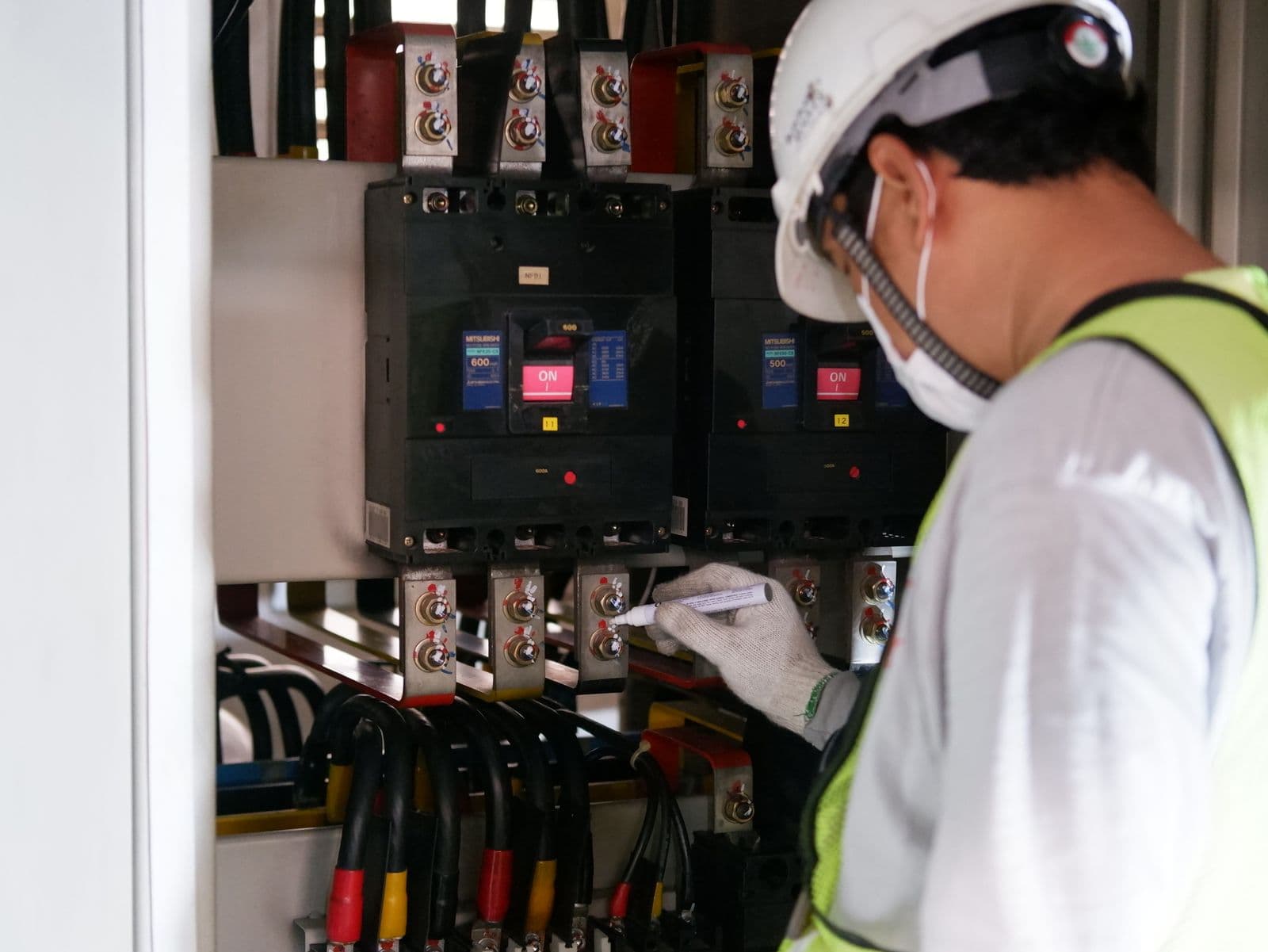 AmpUp electrician in a hard hat inspecting a residential electrical panel