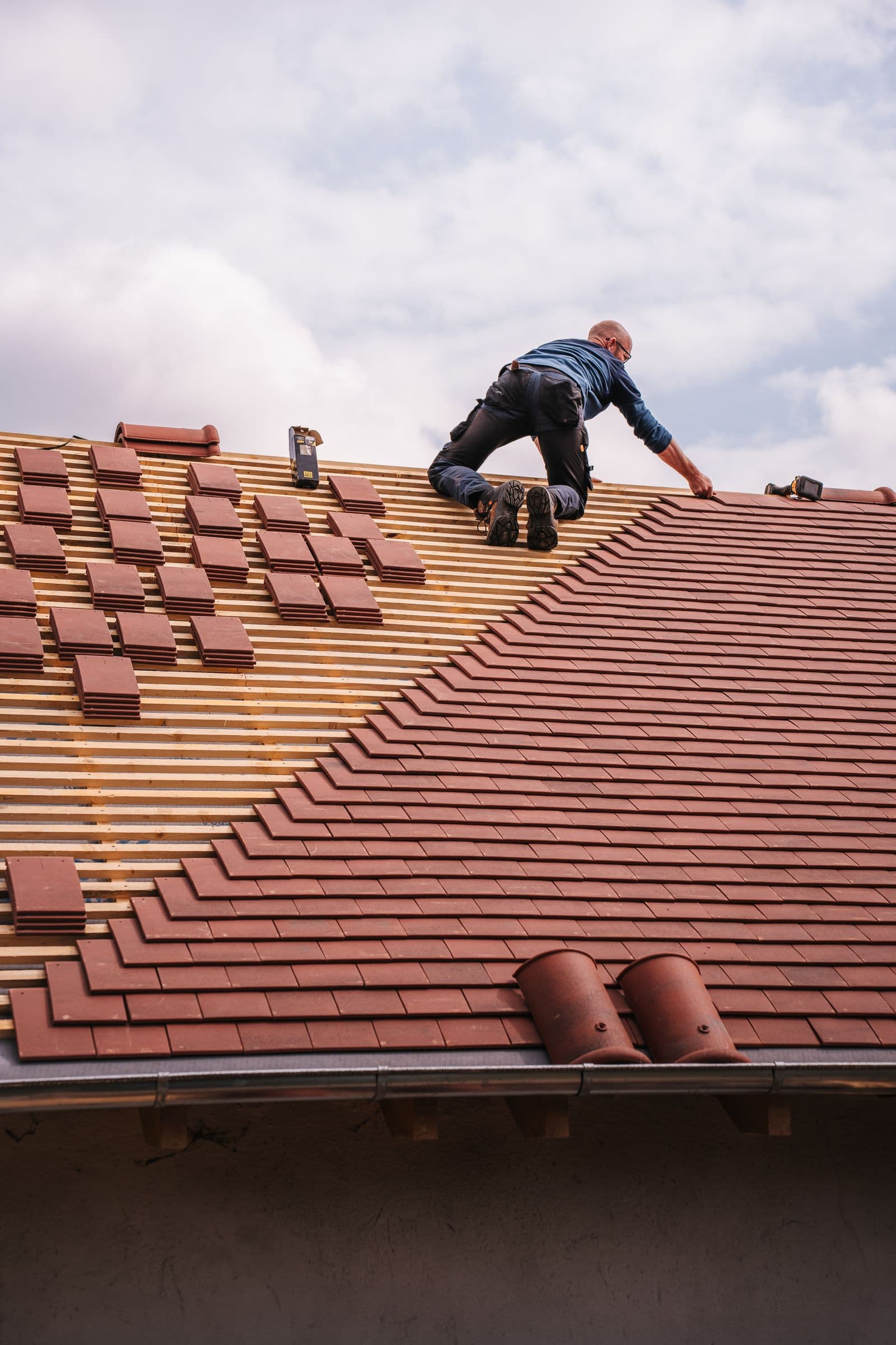Roofer setting tile by hand
