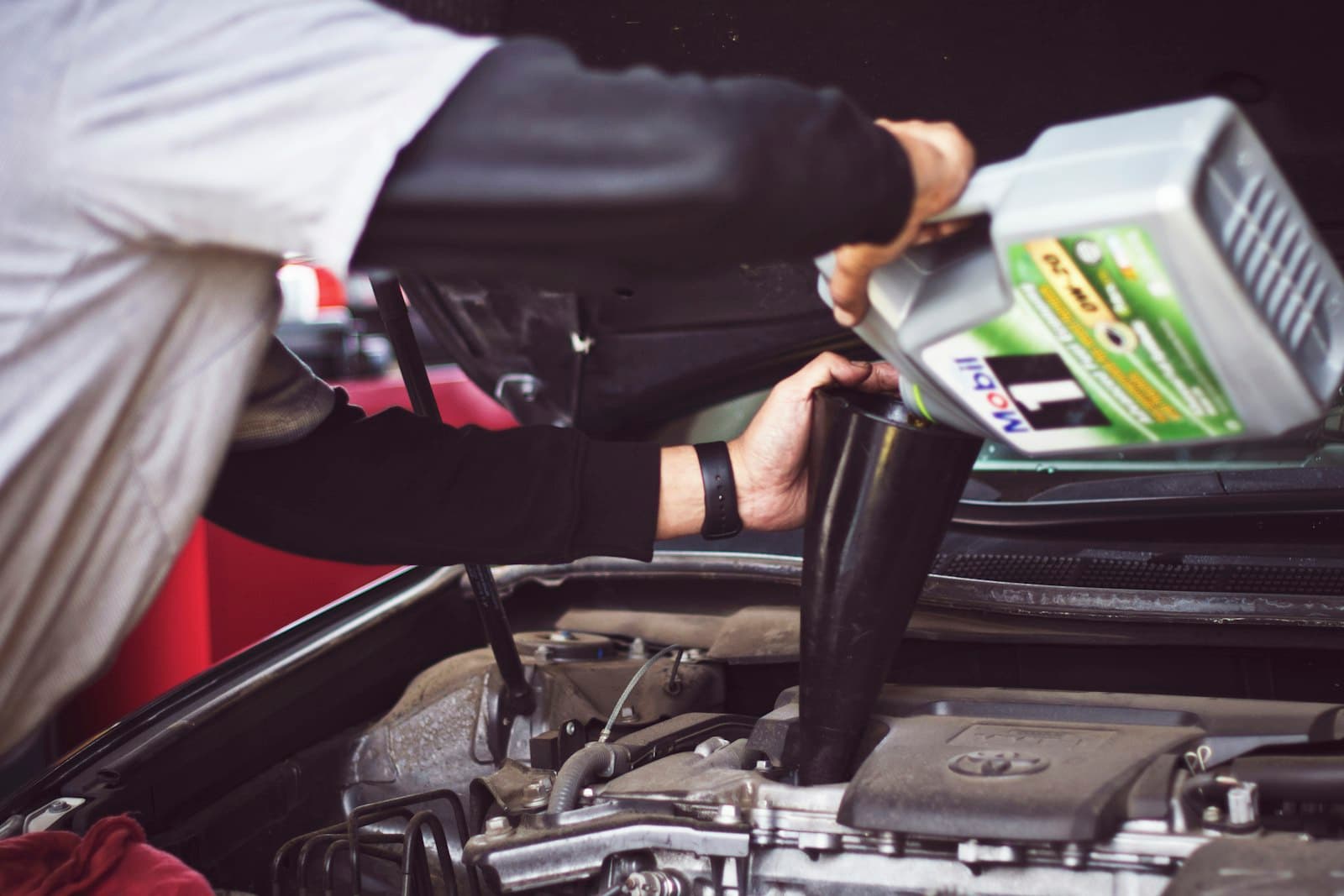 Technician performing a scheduled oil service on a fleet van