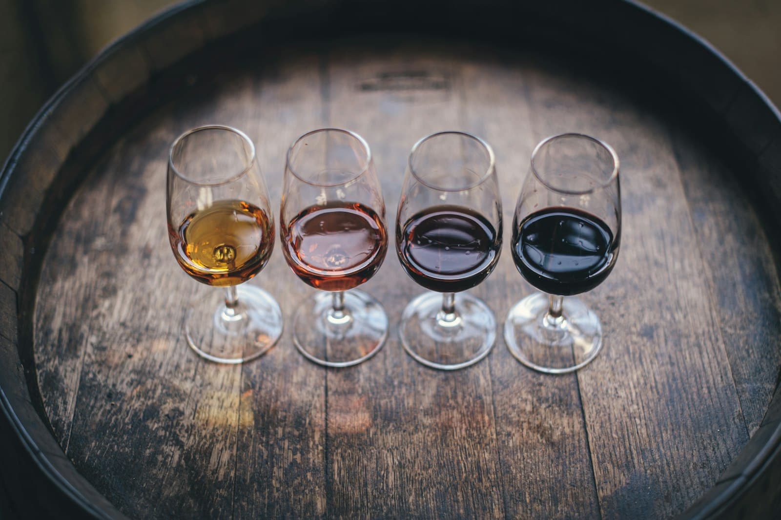 A flight of wines lined up on a wooden bar for a private tasting