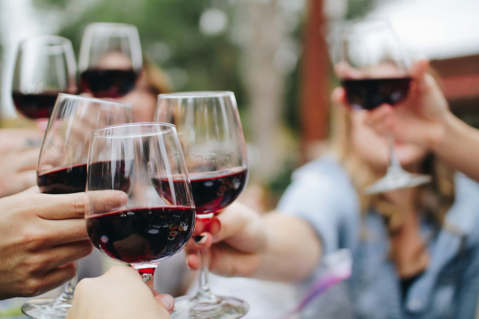 Friends raising glasses of wine together in warm evening light