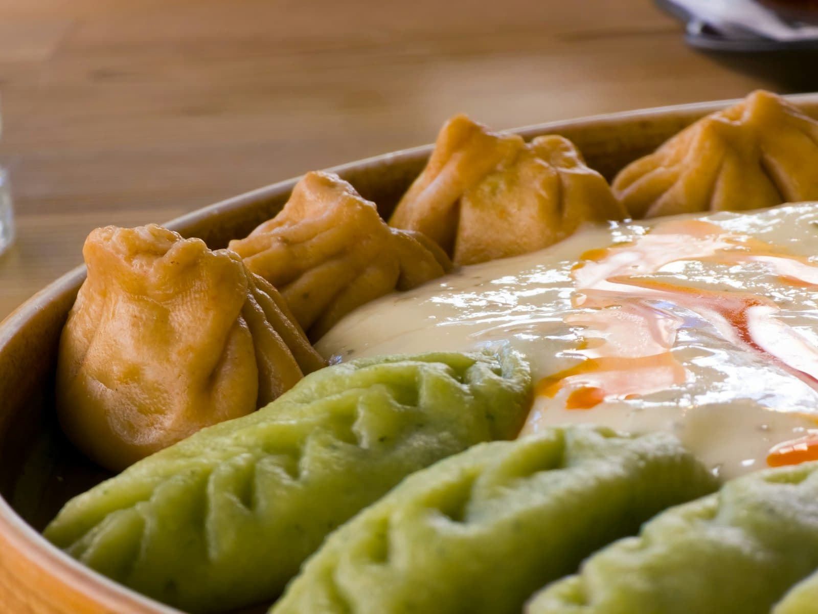Momos smothered in chili sauce and sesame