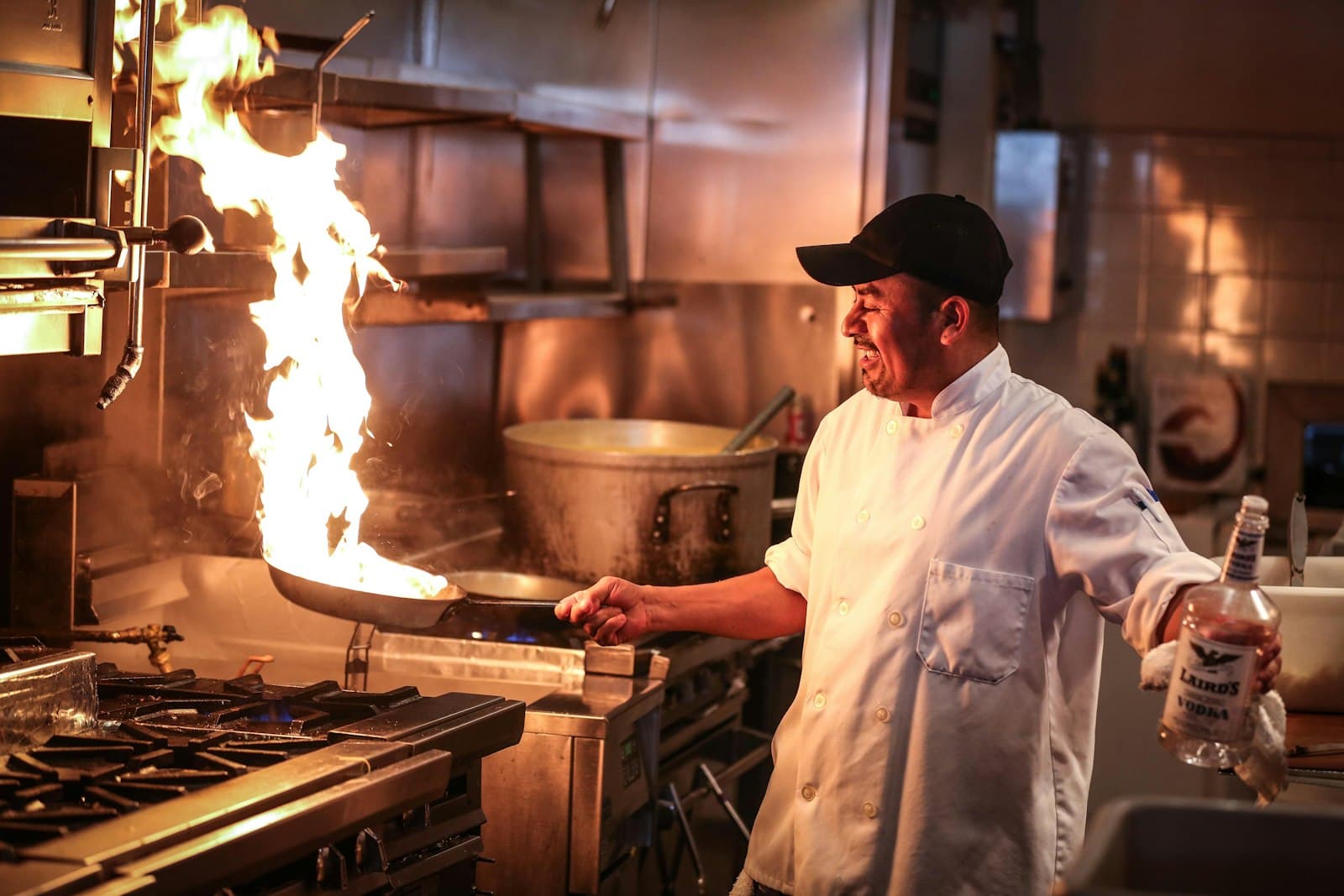 Chef working a wok over roaring flames