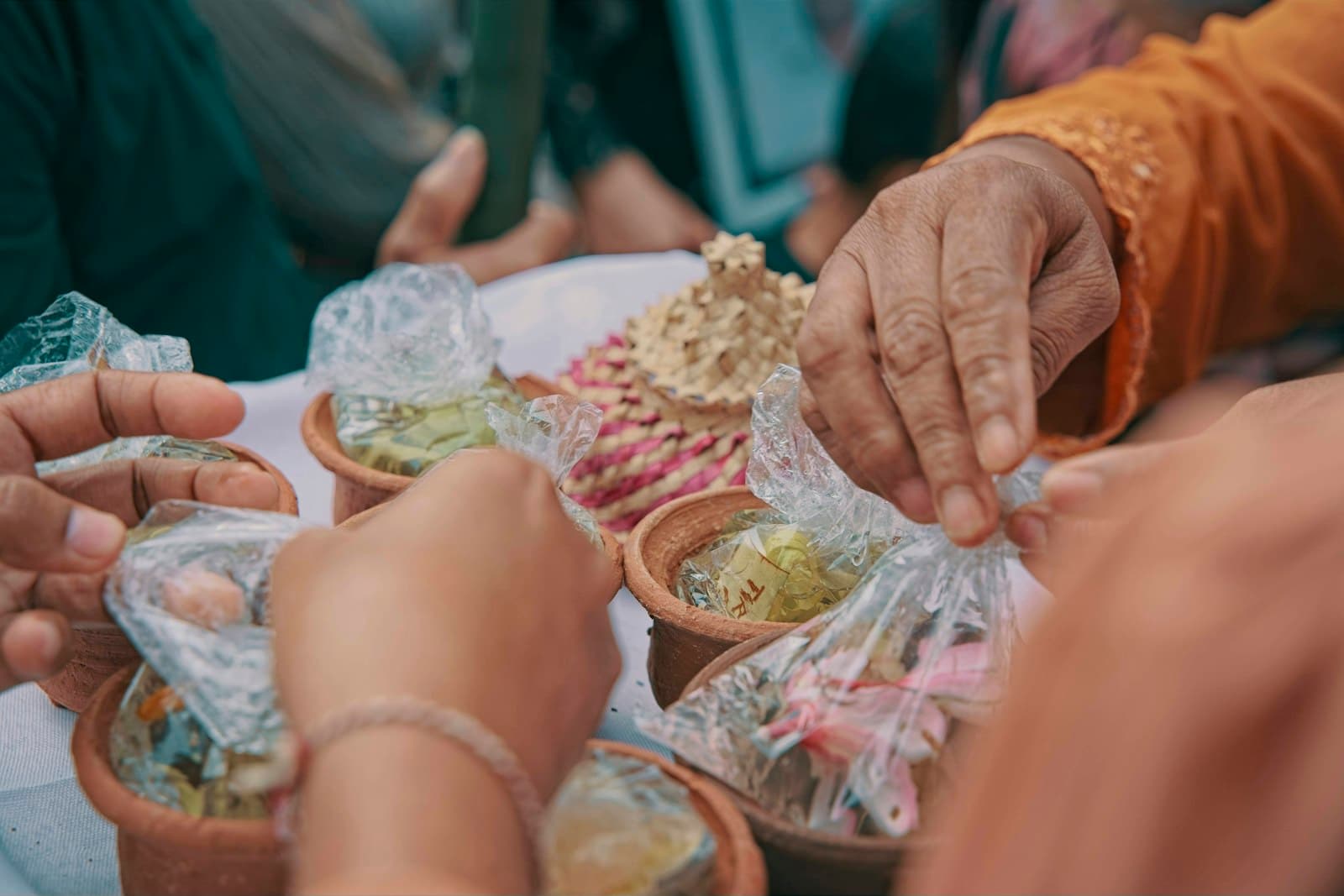 Guests' hands sharing dishes across a full table
