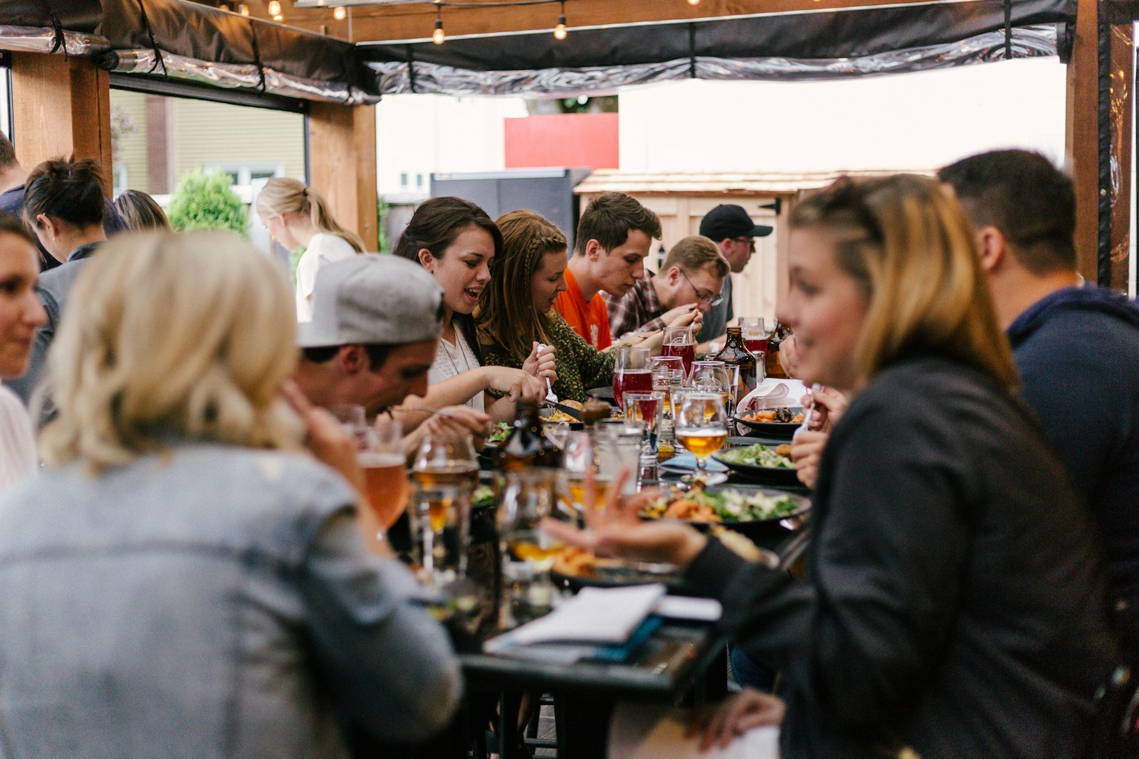 Friends sharing plates and laughing over a long table