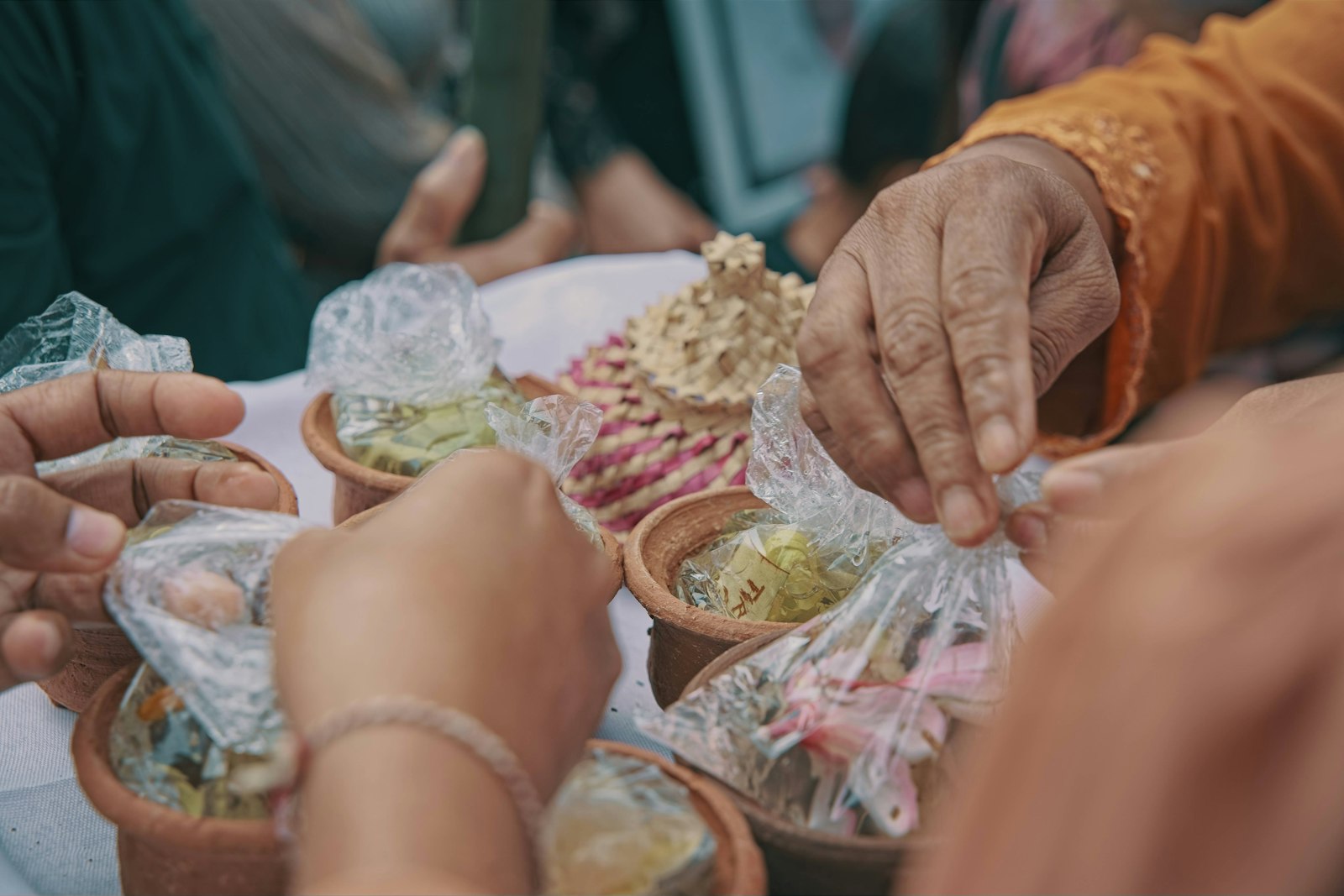 Hands reaching across a shared table of plates at Chiya House